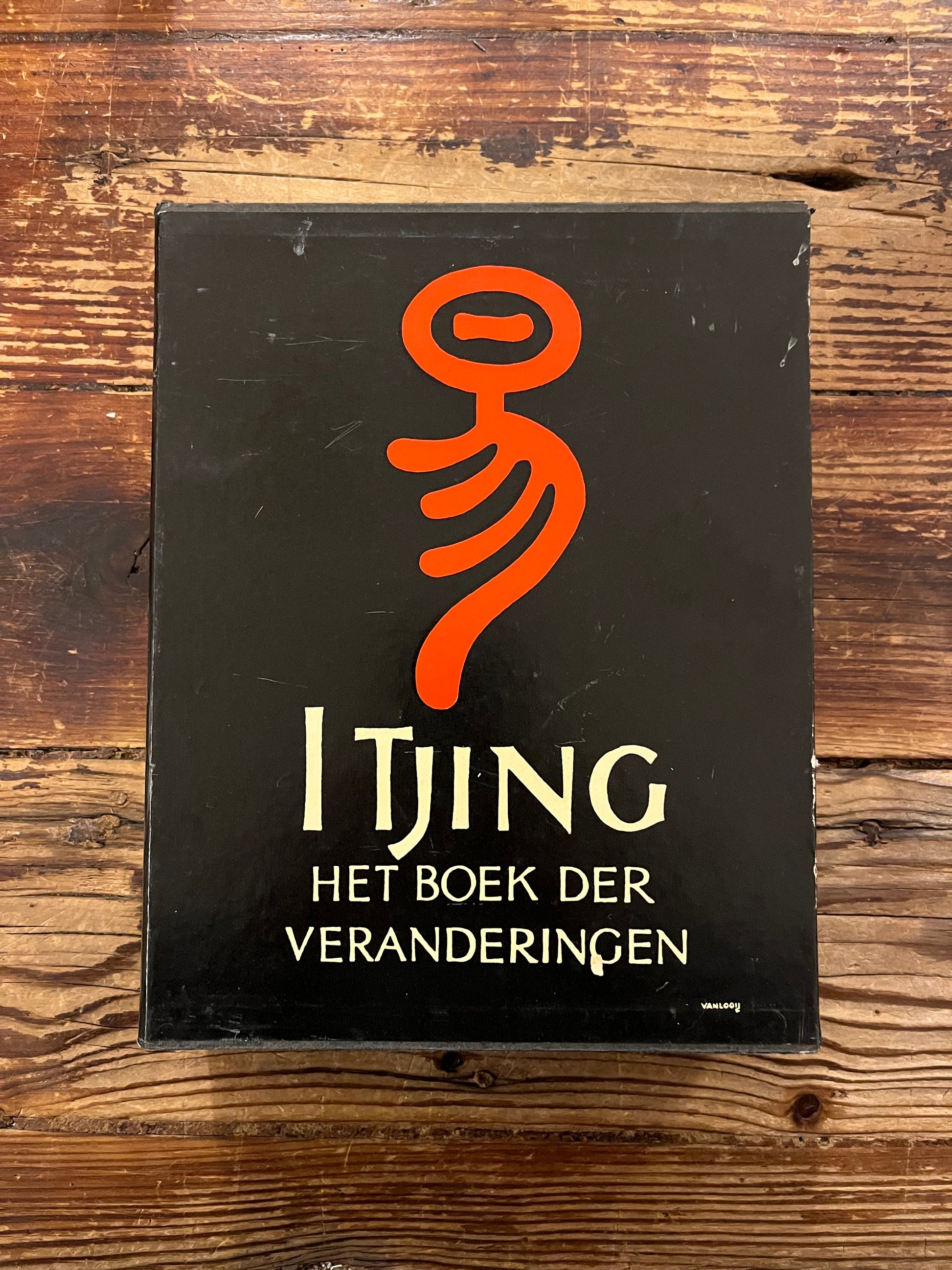 Casette met twee boeken met de titel 'I Tjing: Het Boek Der Veranderingen' op een houten achtergrond