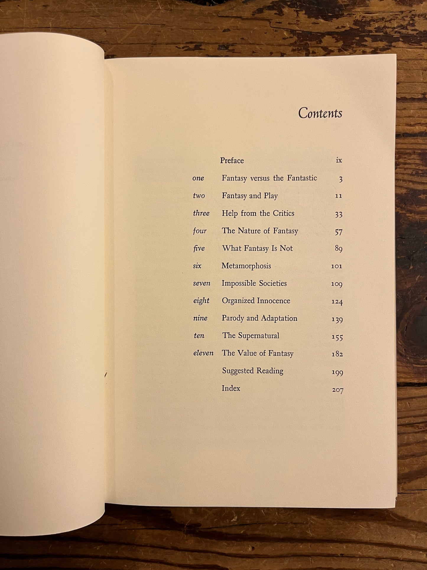 Open book showing the contents of a book titled 'The Game of the Impossible: A Rhetoric of Fantasy' by W.R. Irwin on a wooden surface