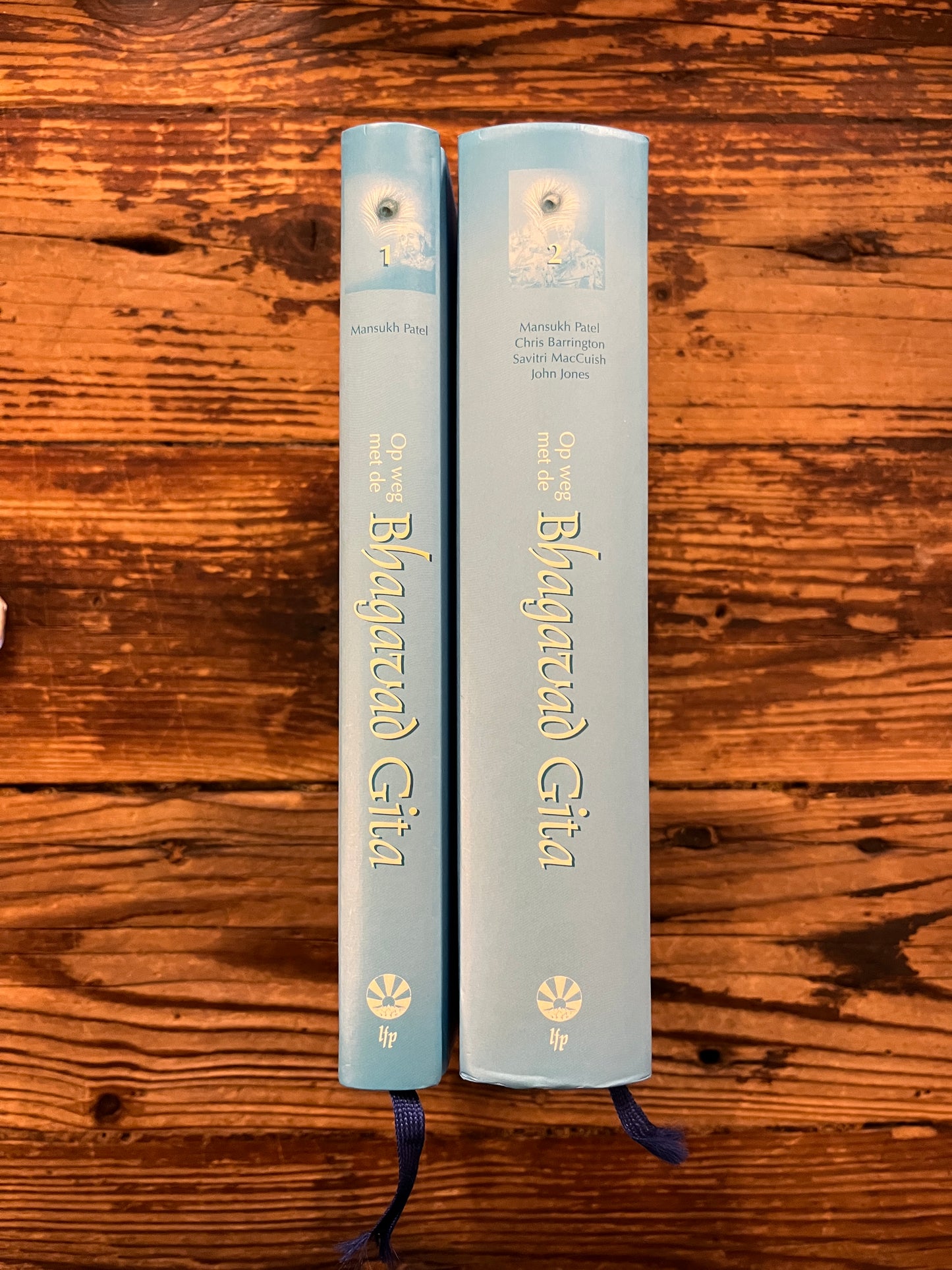 Twee boeken met de titel 'Op weg met de Bhagavad Gita' op een houten achtergrond