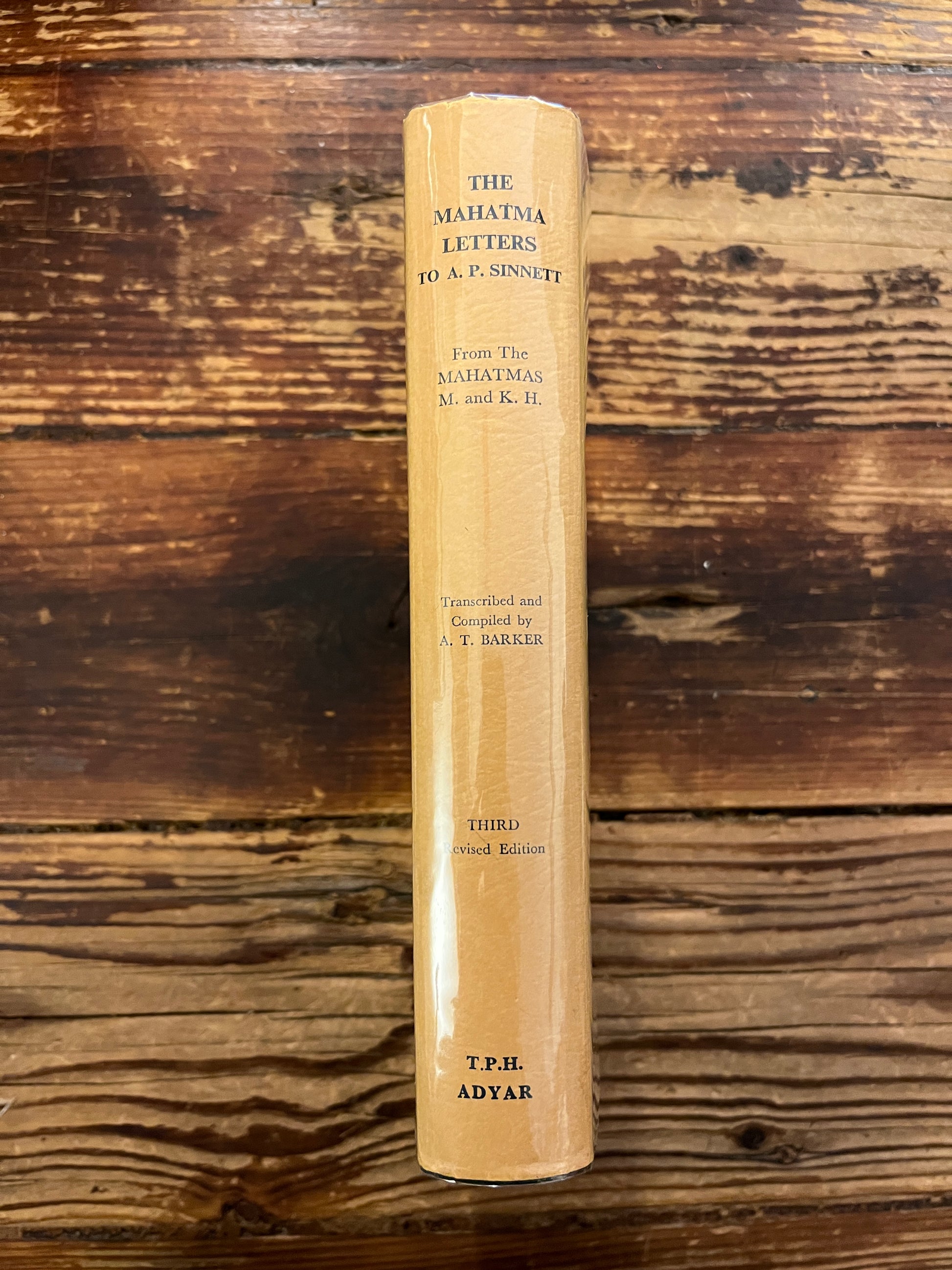 Spine of book titled 'the Mahatma letter to A.P. Sinnett' on a wooden surface 