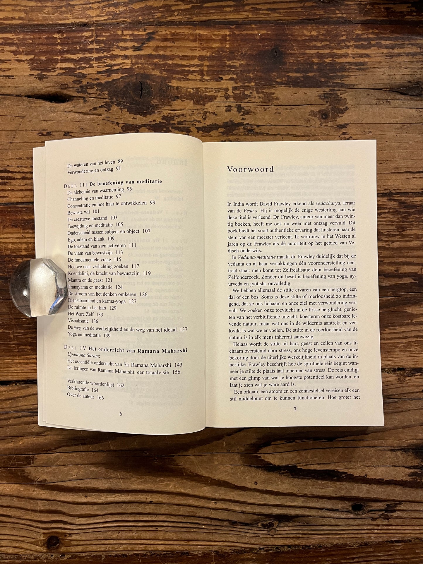 Open boek met de titel 'Vedanta Meditatie' door David Frawley op een houten achtergrond 