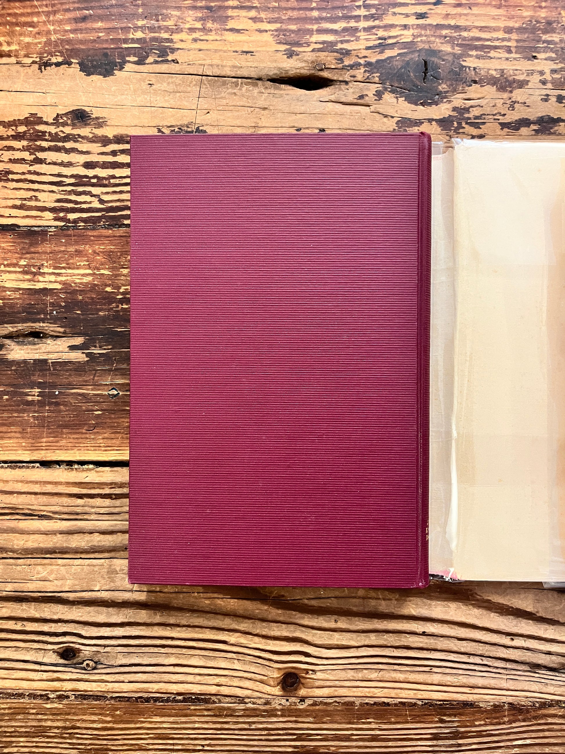 Achterkant van boek zonder stof omslag met de titel 'Thomas van Aquino' door Dr. Ferd. Sassen op een houten achtergrond 