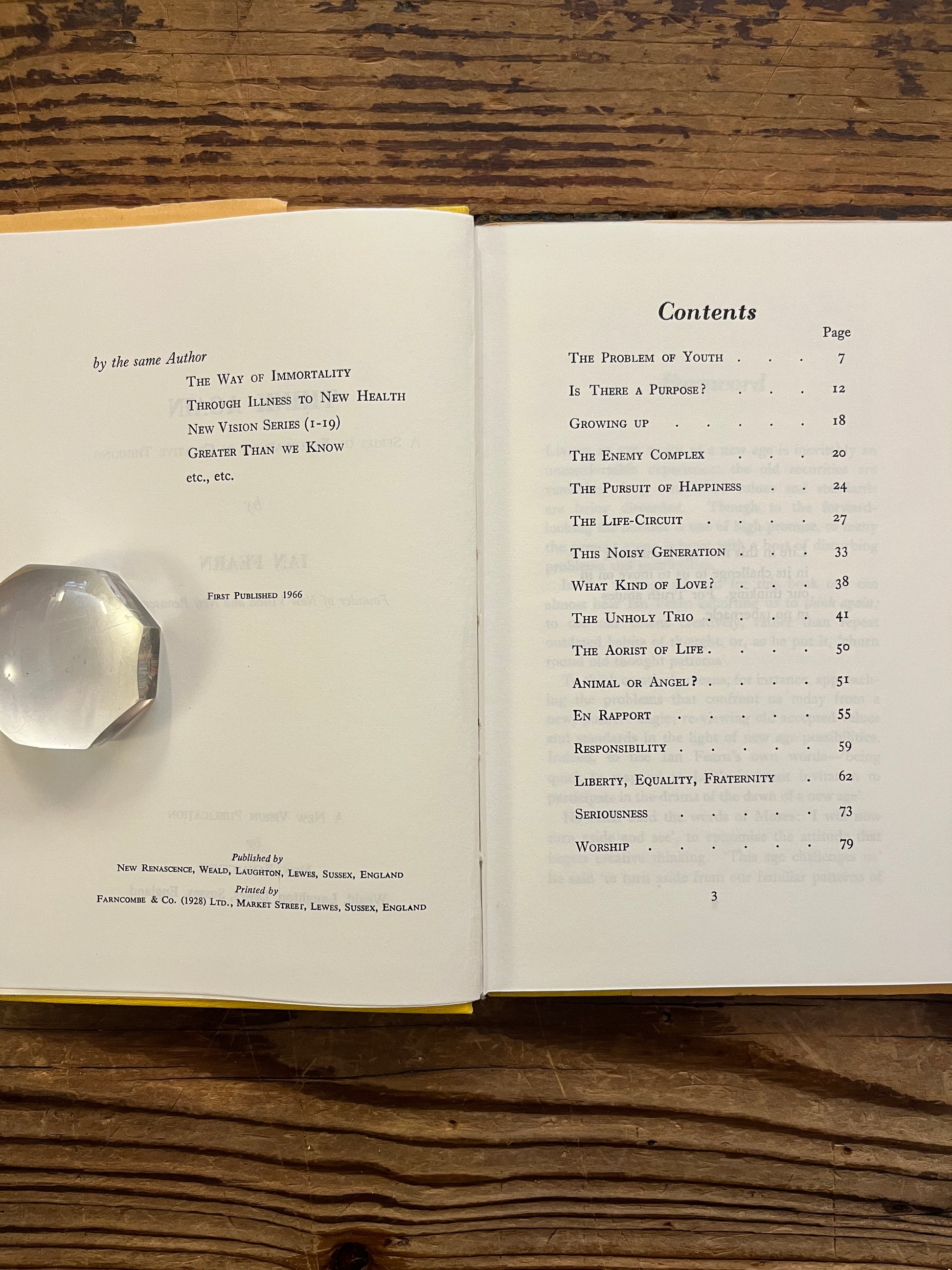 Open book with the title 'Think Again' by Ian Fearn on a wooden surface