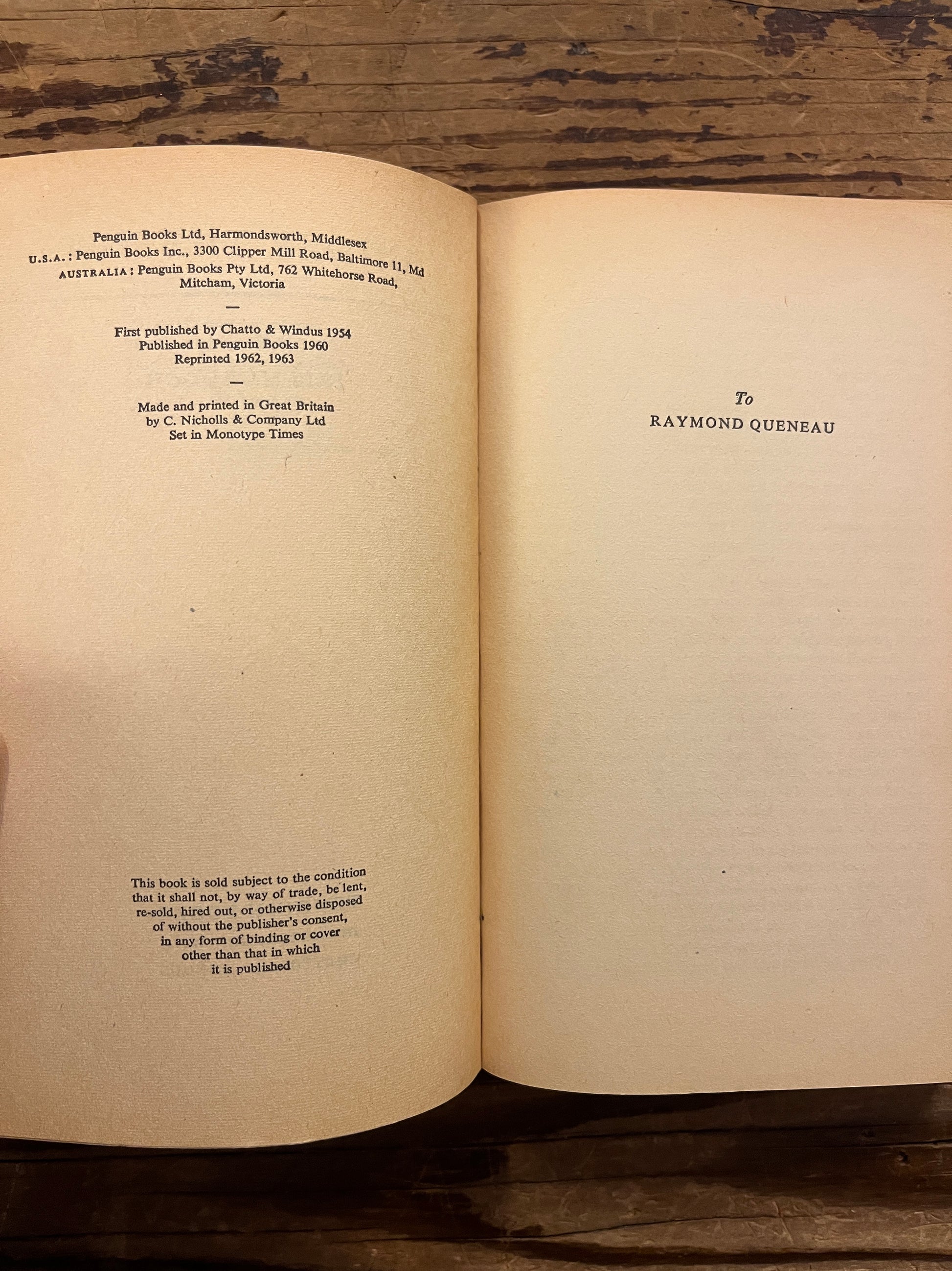 Open Penguin book titled 'under the Net' by Iris Murdoch on a wooden surface