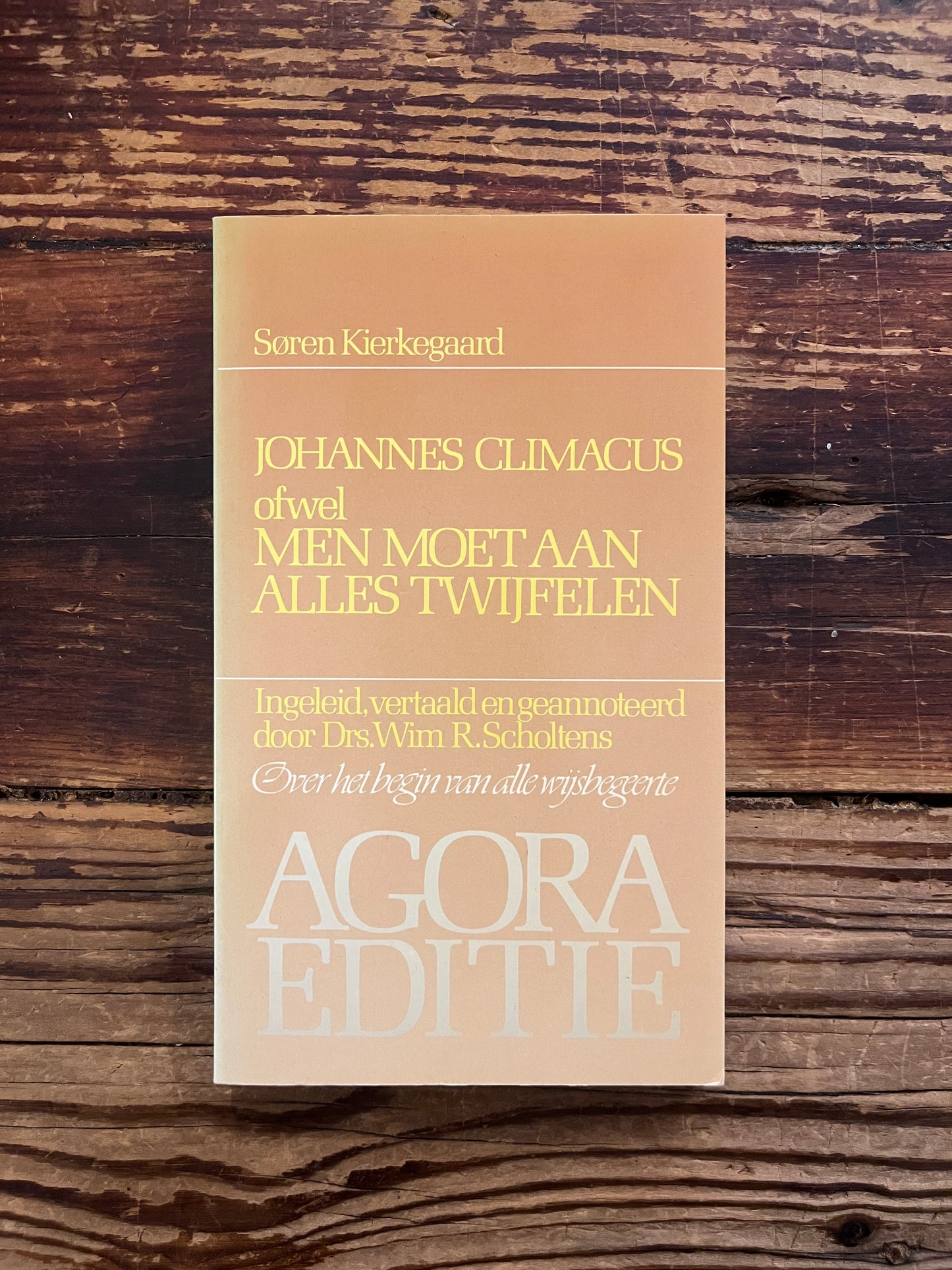 foto van de cover van het boek "men moet aan alles tijwfelen"op houten achtergrond