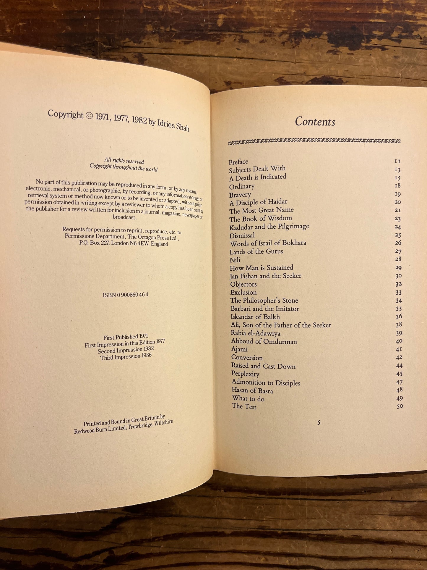 Open book titled 'Thinkers of the East' by Idries Shah with a wooden surface background