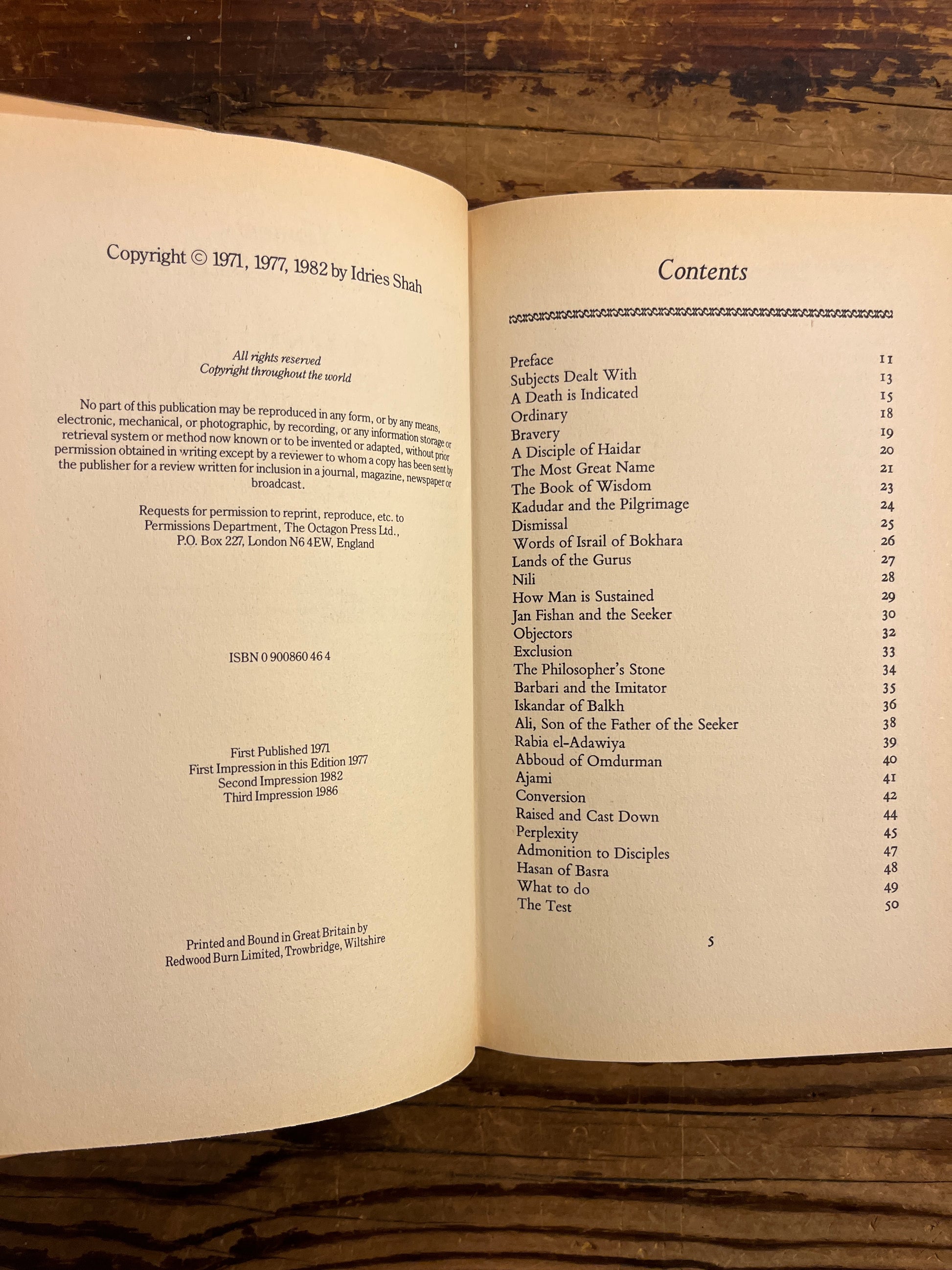 Open book titled 'Thinkers of the East' by Idries Shah with a wooden surface background