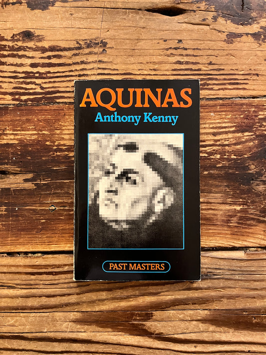 Front cover of book titled 'Aquinas by Anthony Kenny on a wooden surface