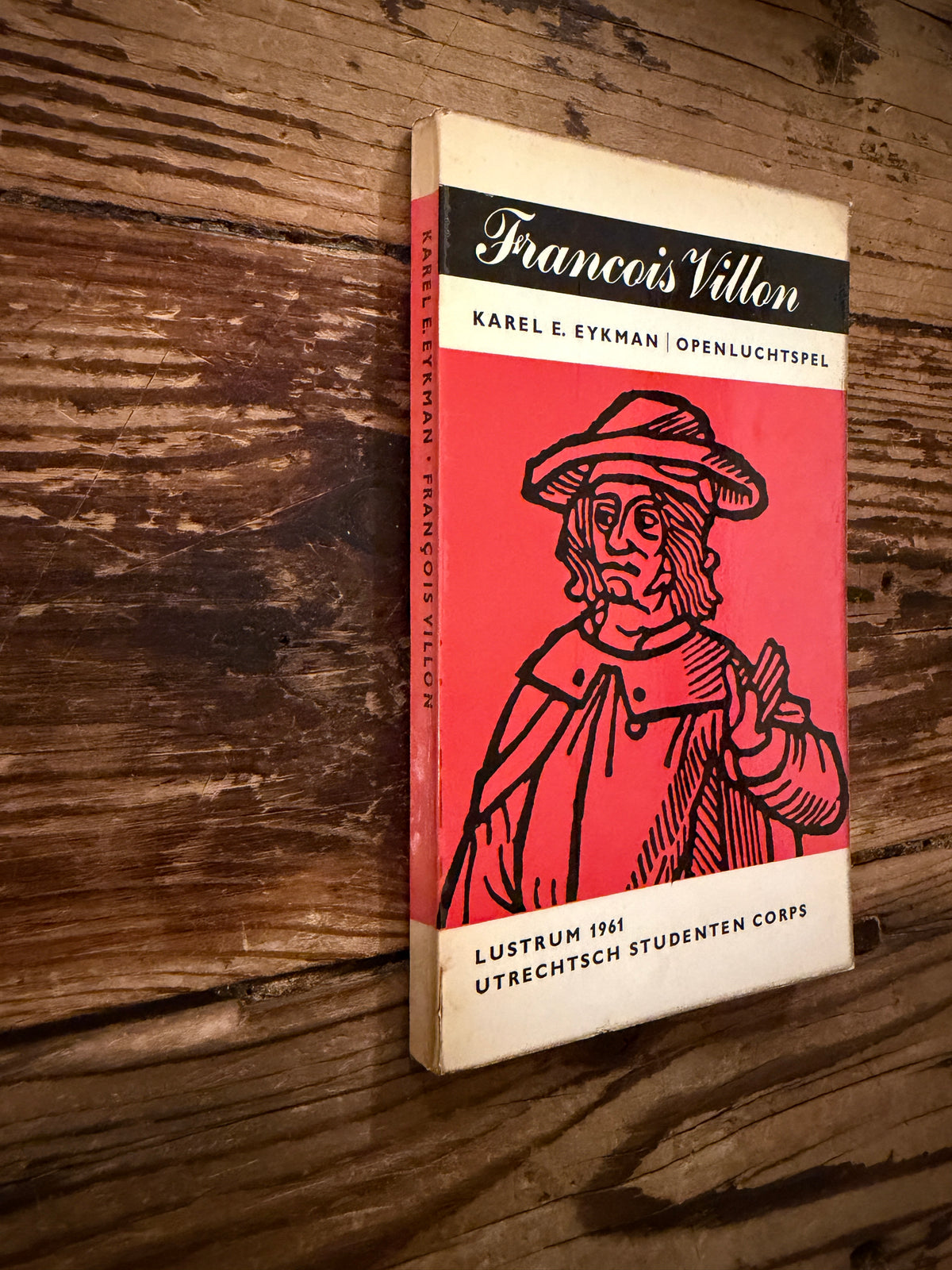 Voorkant en rug van een boek met de titel 'Francois Villon, openluchtspel, lustrum 1961' door Karel Eykman op een houten achtergrond