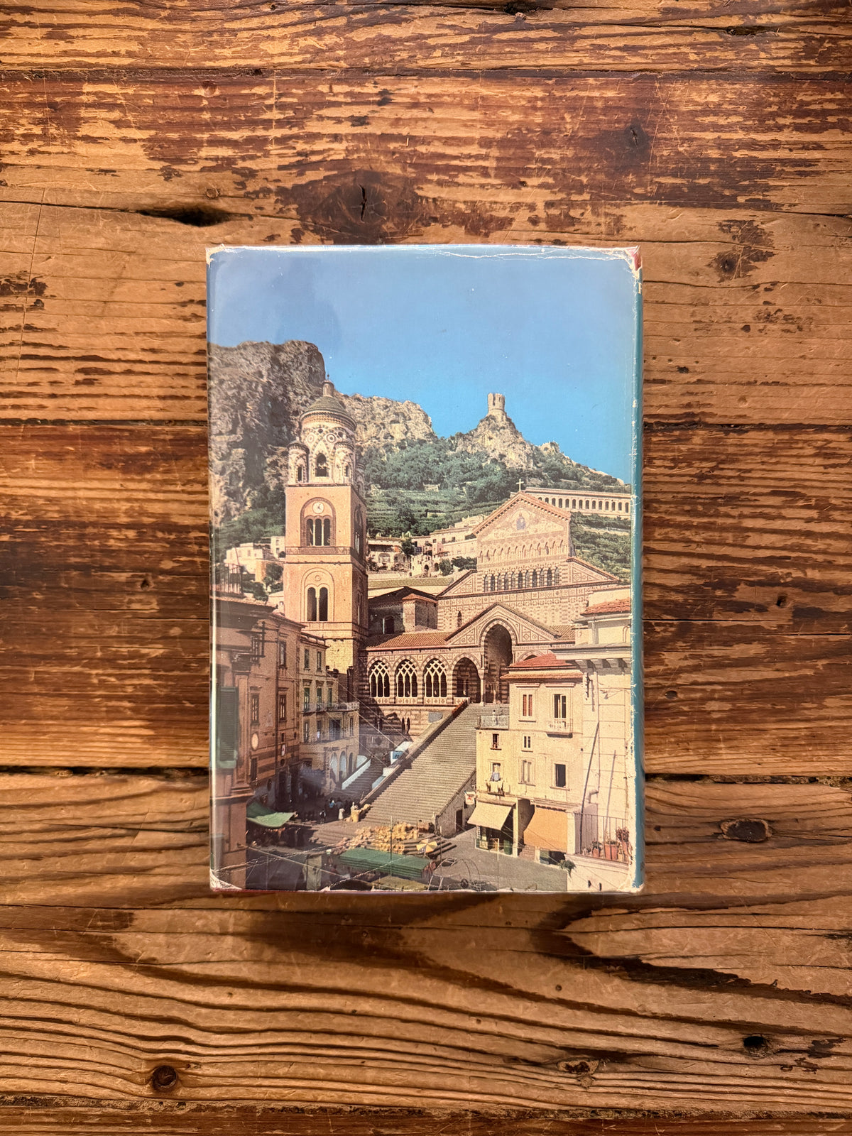 Back cover of a book with the title 'The Cathedrals of Italy' by J.W. Franklin on a wooden surface