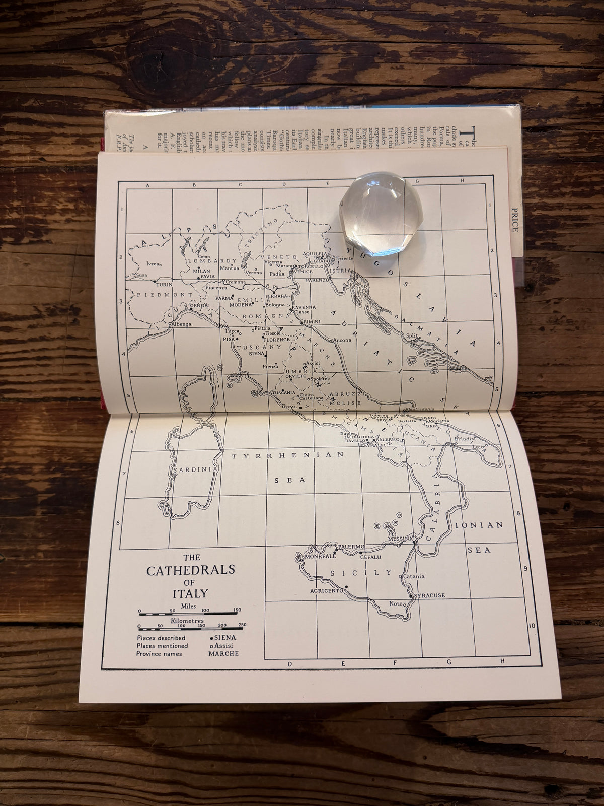 Open book with the title 'The Cathedrals of Italy' by J.W. Franklin on a wooden surface