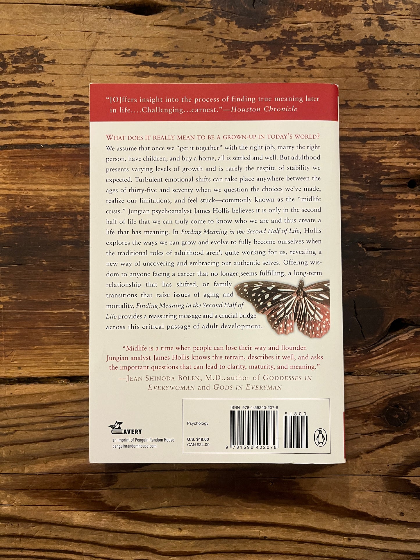 Backcover of book titled 'Finding Meaning in the Second Half of Life' by James Hollis on a wooden surface