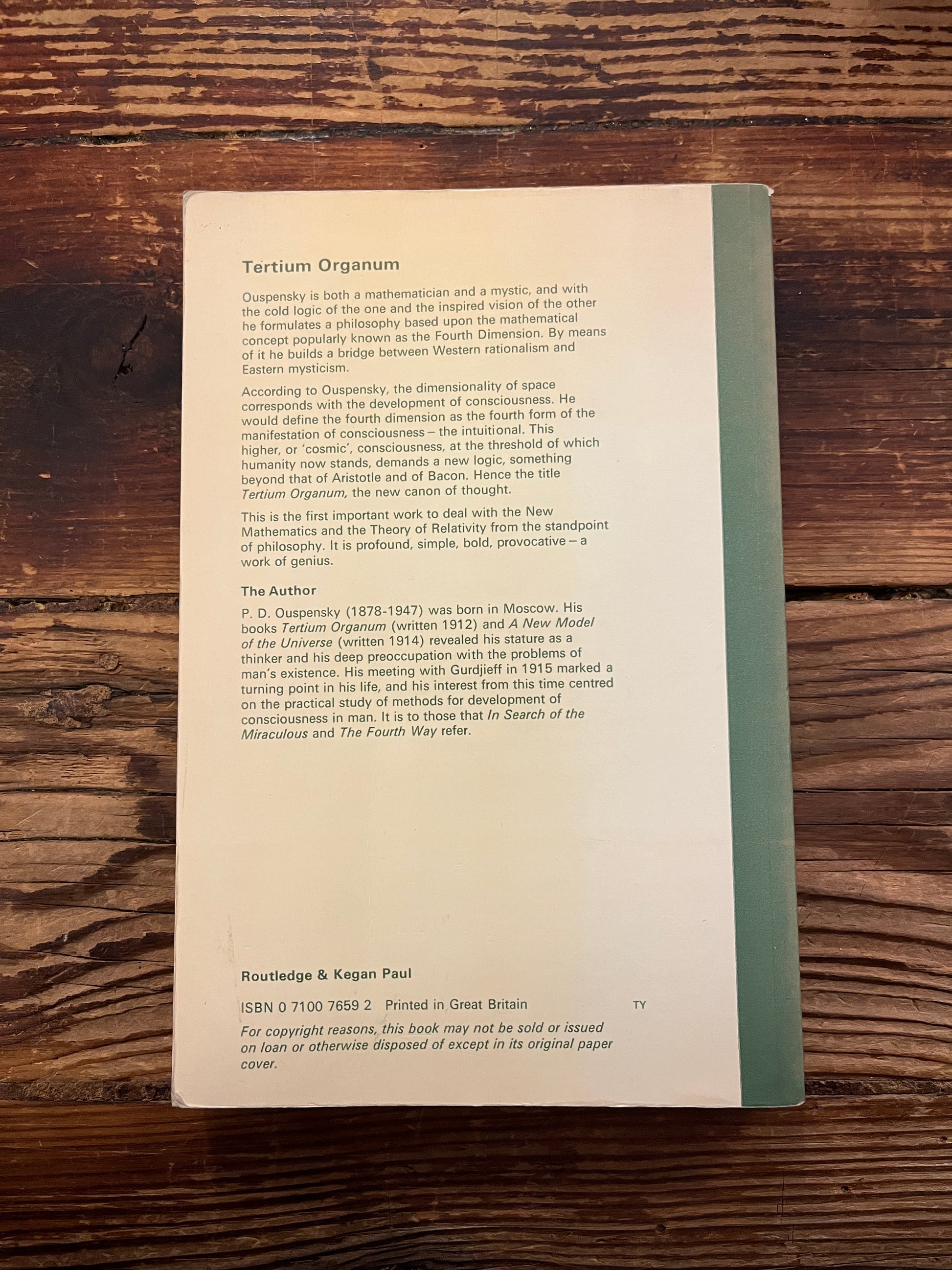 Back cover book titled 'Tertium Organum' by P.D. Ouspensky on a wooden surface
