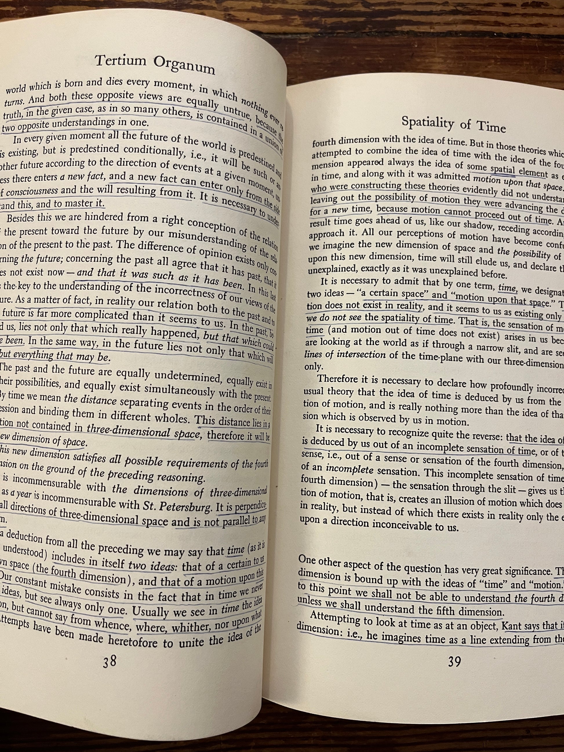Open book titled 'Tertium Organum' by P.D. Ouspensky on a wooden surface