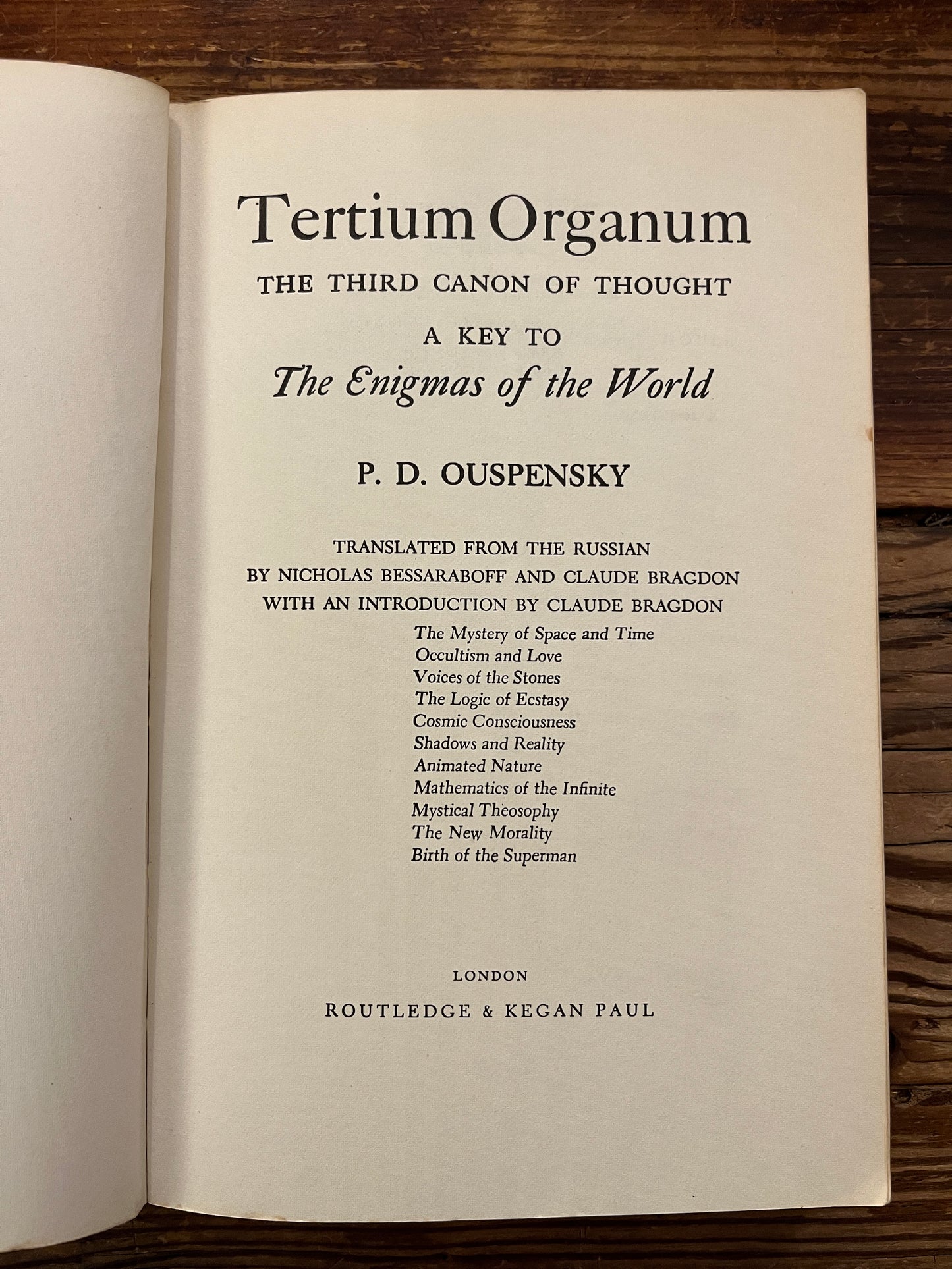 Open book titled 'Tertium Organum' by P.D. Ouspensky on a wooden surface