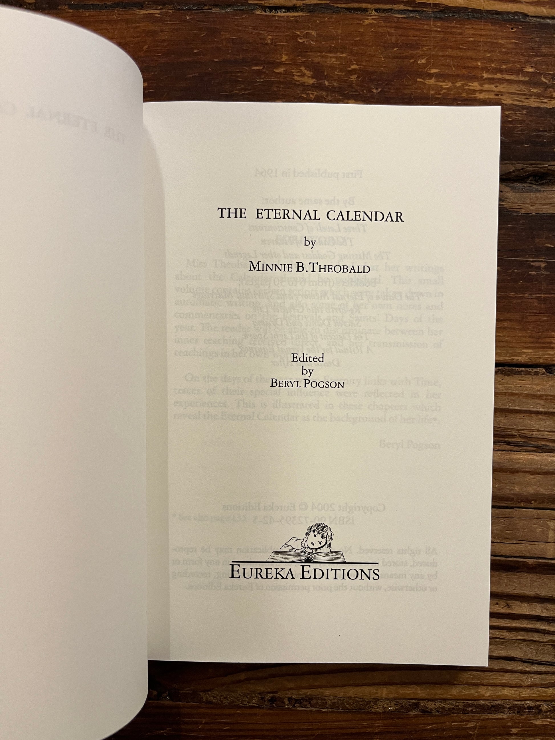 Open book titled 'The Eternal Calendar' by Minnie Theobald with a simple white design on the cover.