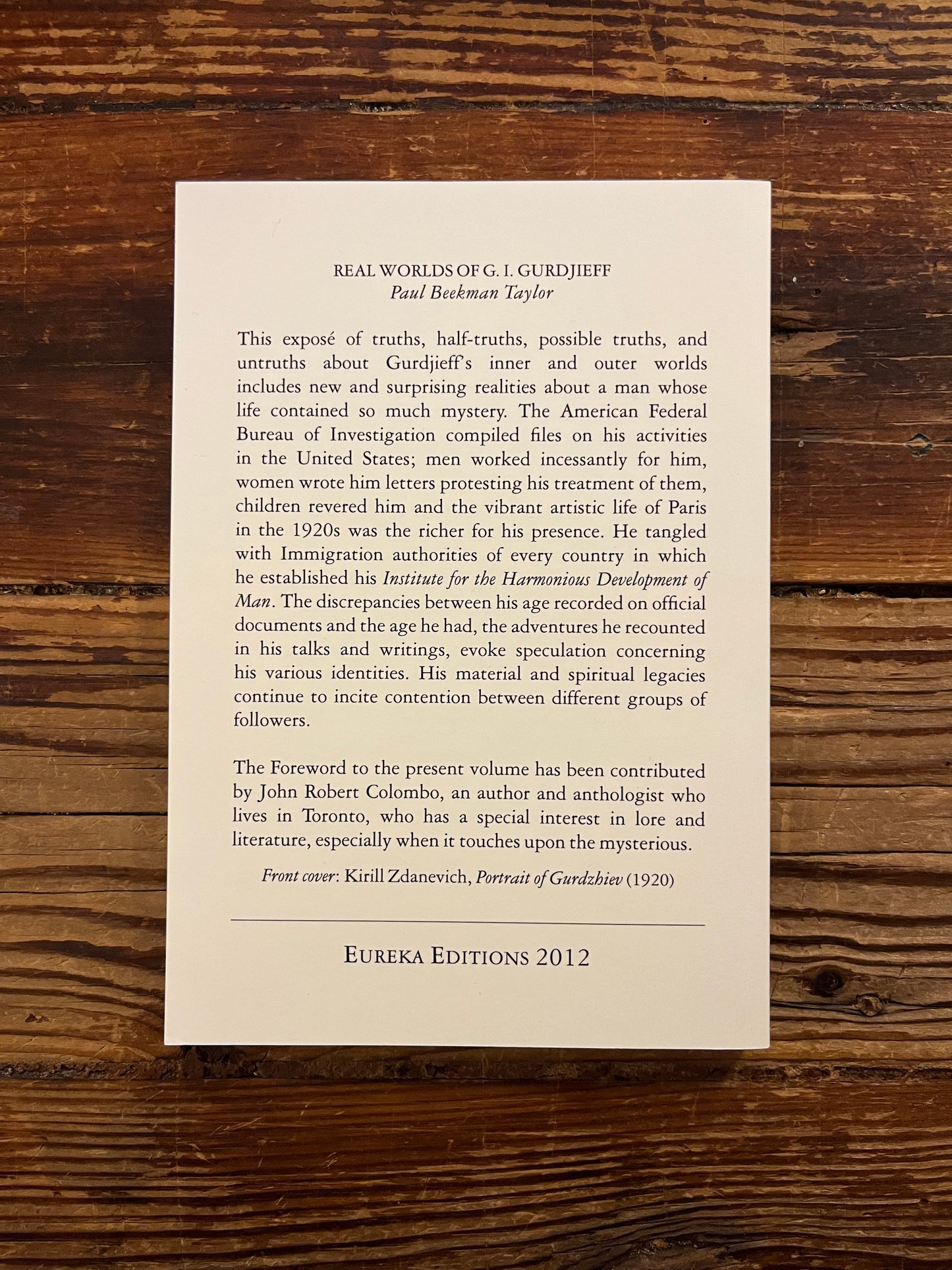 Back cover of book titled 'Real Worlds Of G.I. Gurdjieff' by Paul Beekman Taylor on a wooden surface 