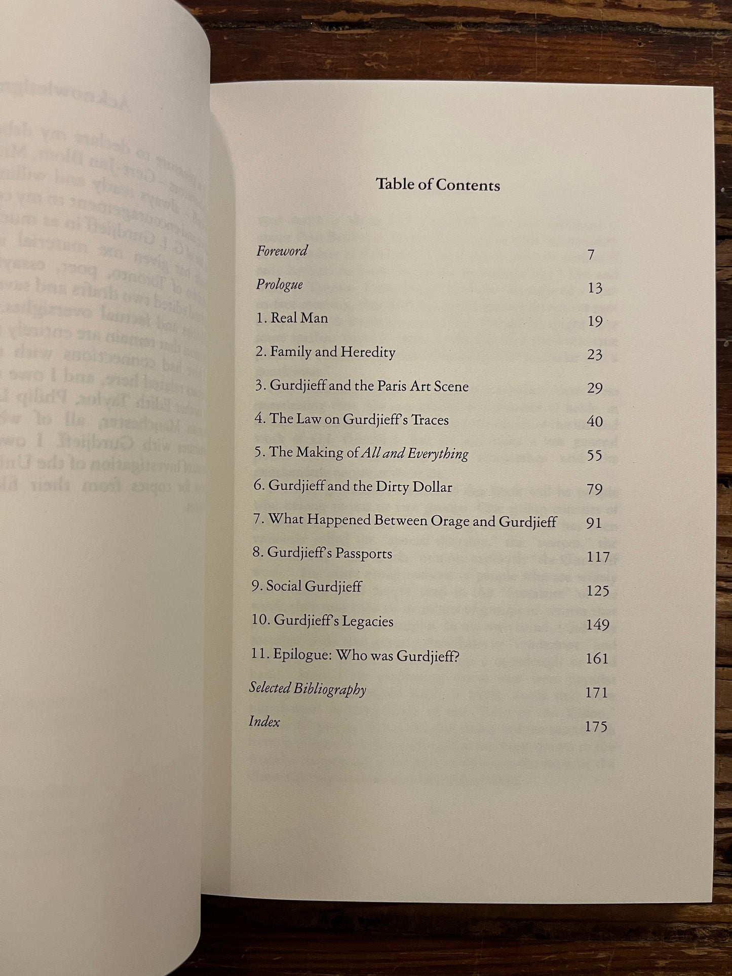 Open book titled 'Real Worlds Of G.I. Gurdjieff' by Paul Beekman Taylor on a wooden surface 