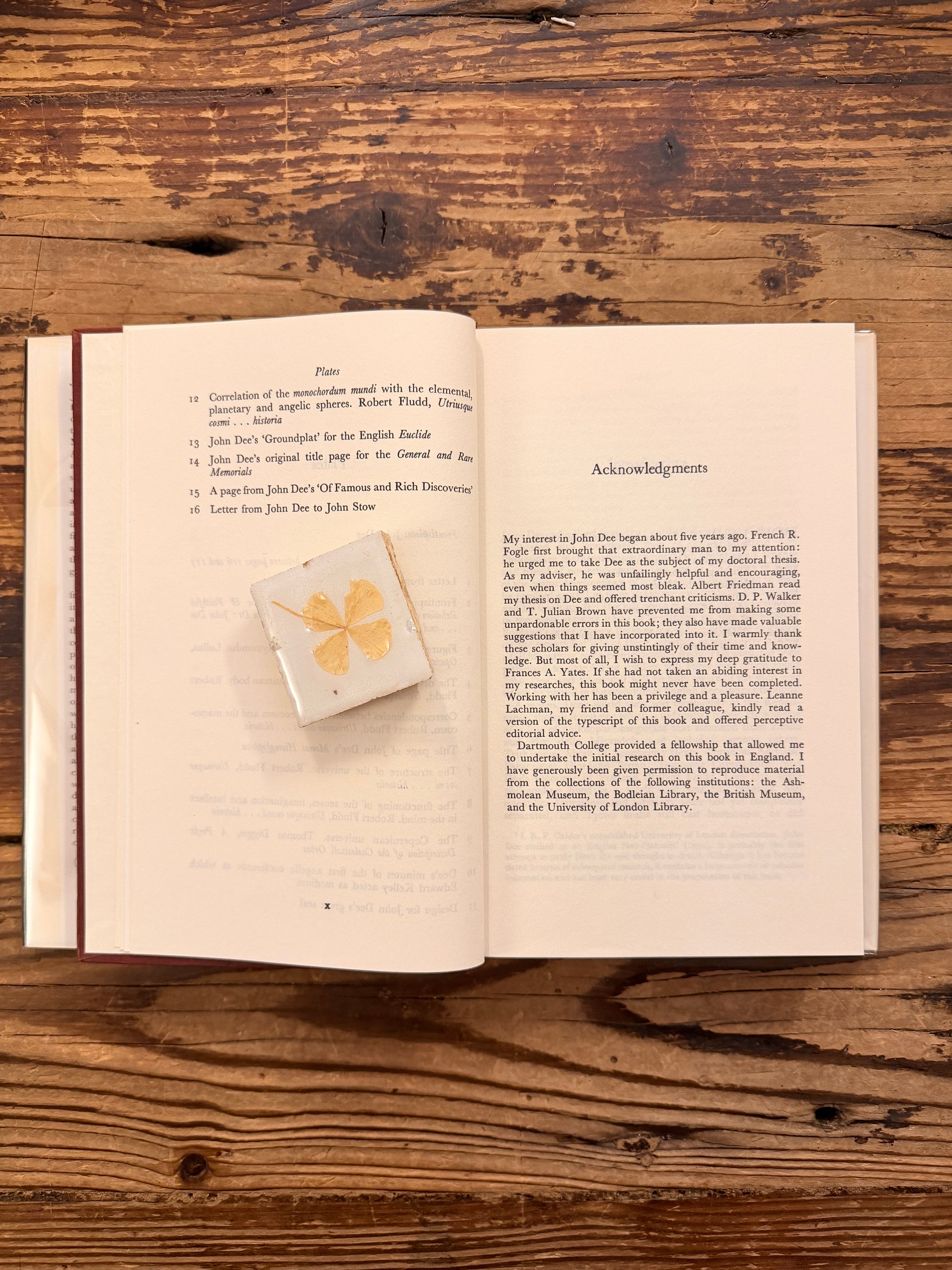 Open book titled 'John Dee: The World of an Elizabethan Magus' by Peter J. French on a wooden surface