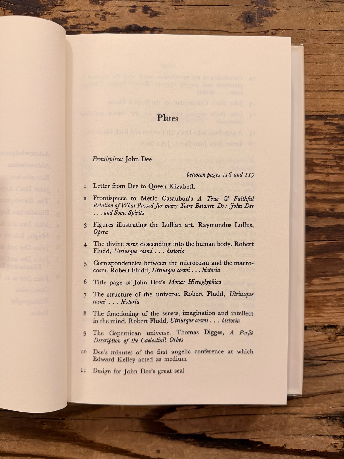 Open book titled 'John Dee: The World of an Elizabethan Magus' by Peter J. French on a wooden surface