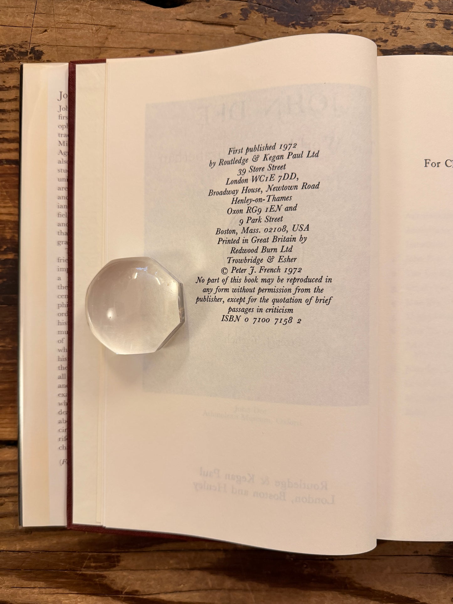 Open book titled 'John Dee: The World of an Elizabethan Magus' by Peter J. French on a wooden surface