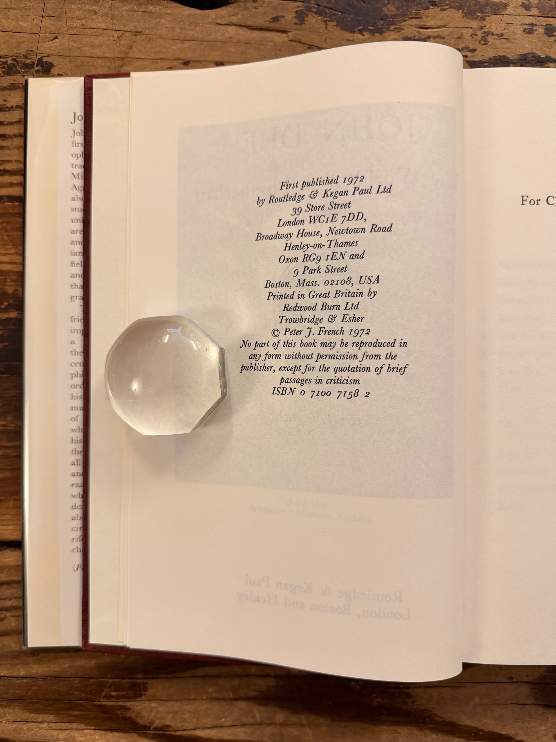 Open book titled 'John Dee: The World of an Elizabethan Magus' by Peter J. French on a wooden surface