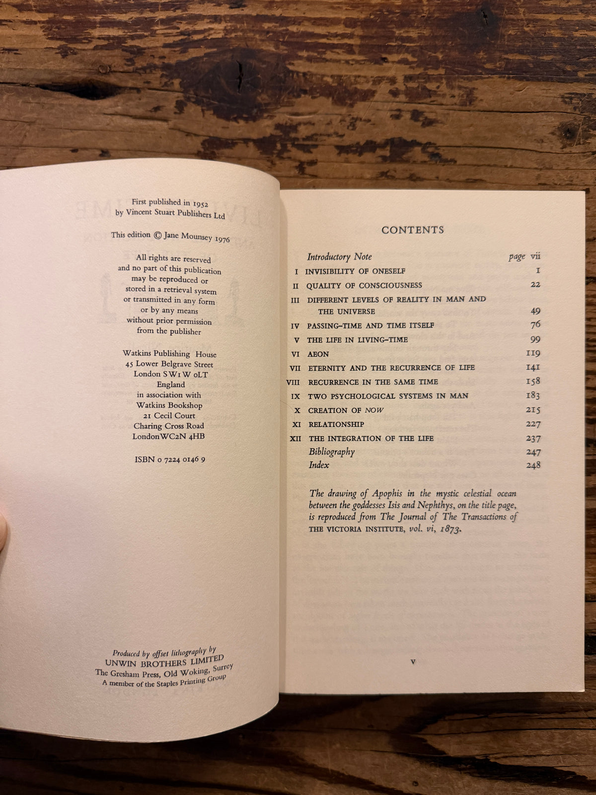 Open book showing the content with the title 'Living Time and the Integration of the Life' by Maurice Nicoll, a 1976 Watkins Edition lying on a wooden surface 