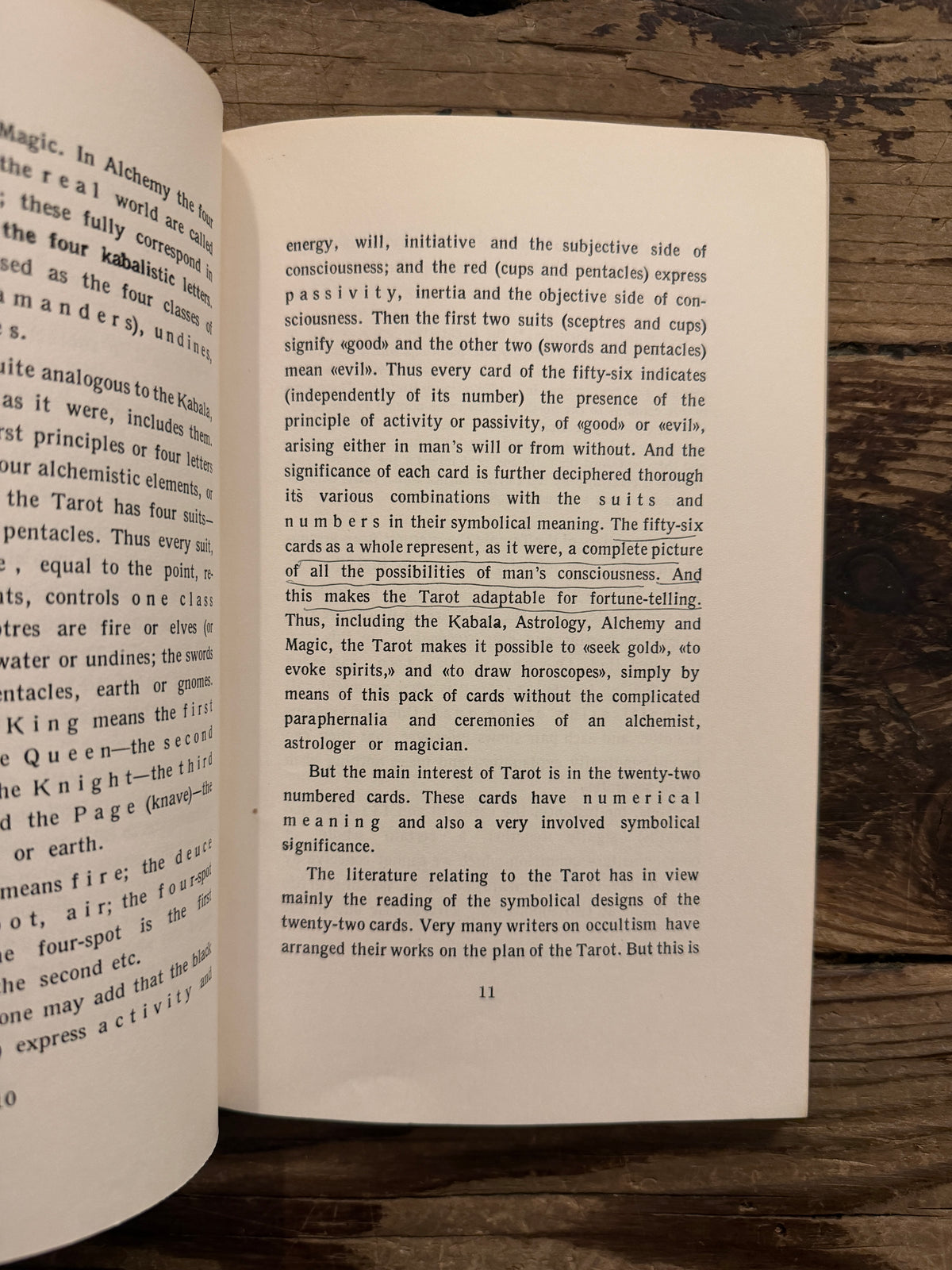 Open book with the title  'The symbolism of the Tarot, philosophy of Occultism in Pictures and Numbers' by P. D. Ouspensky, lying on a wooden surface