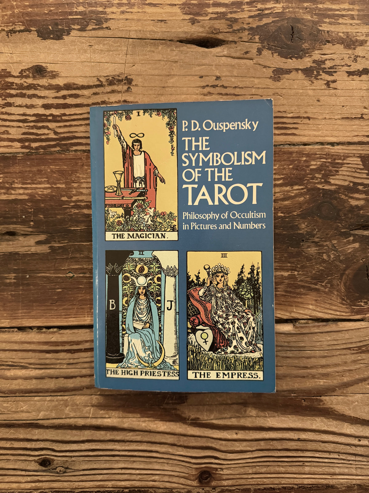 Front cover of 'The symbolism of the Tarot, philosophy of Occultism in Pictures and Numbers' by P. D. Ouspensky, lying on a wooden surface