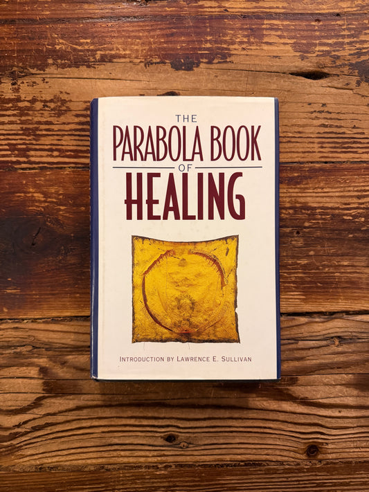 Front cover of 'the Parabola book of healing' on a wooden surface 