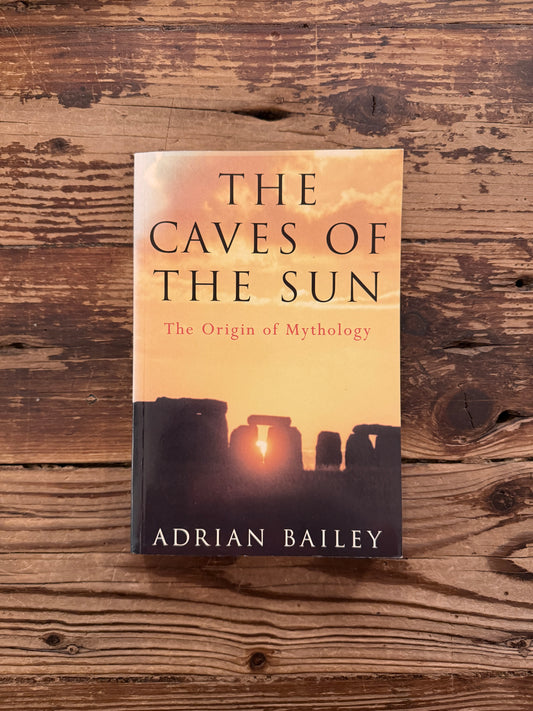 Front cover of book titled 'The Caves of the Sun: The Origin of Mythology' by Adrian Bailey, lying on a wooden surface