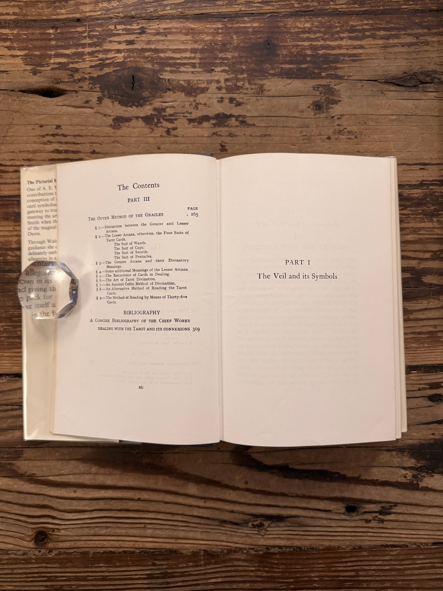 Open book titled 'The Pictorial Key to the Tarot' by A.E. on a wooden surface 