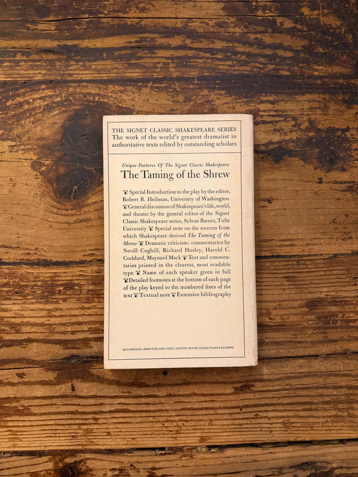 photo of the cover of the book "The taming of the shrew" on a wooden background