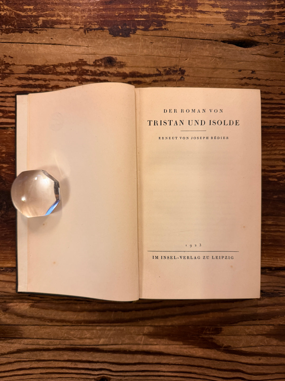 Title page of book in German titled 'Tristan und Isolde' by Joseph Bédier, published in 1923, exposed on a wooden surfacer 