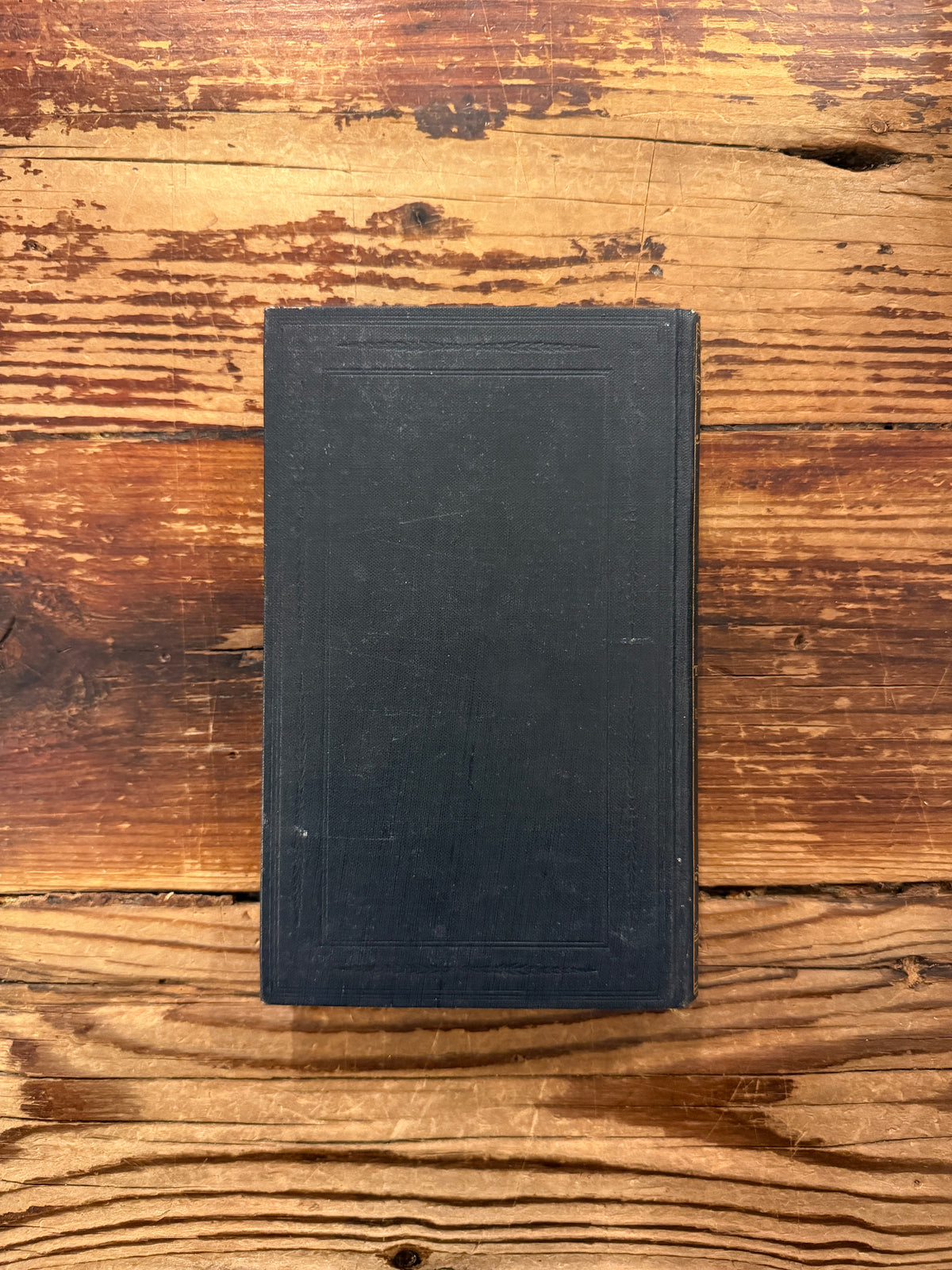 Back cover of book in German titled 'Tristan und Isolde' by Joseph Bédier, published in 1923, exposed on a wooden surfacer 