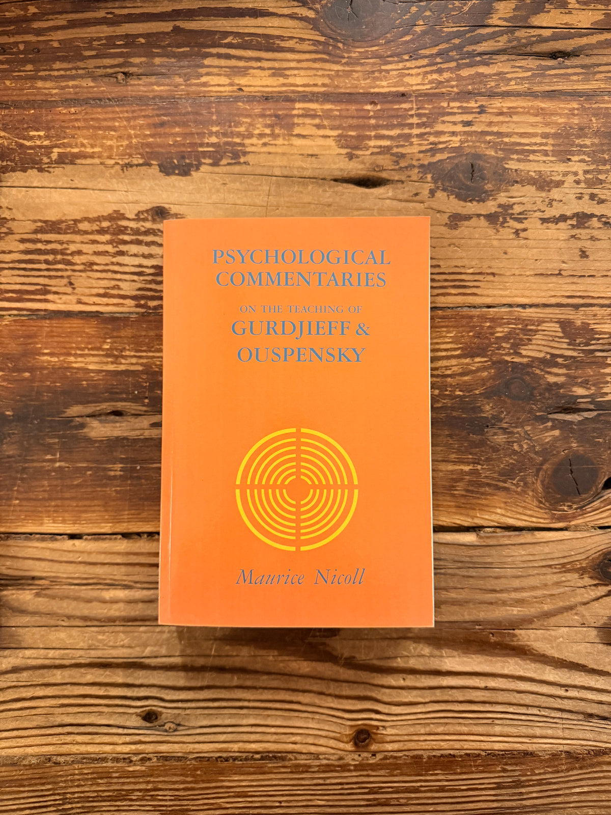 Front cover of a book titled 'Psychological commentaries on the teaching of Gurdjieff & Ouspensky, volume III' by Maurice Nicoll lying on a wooden surface