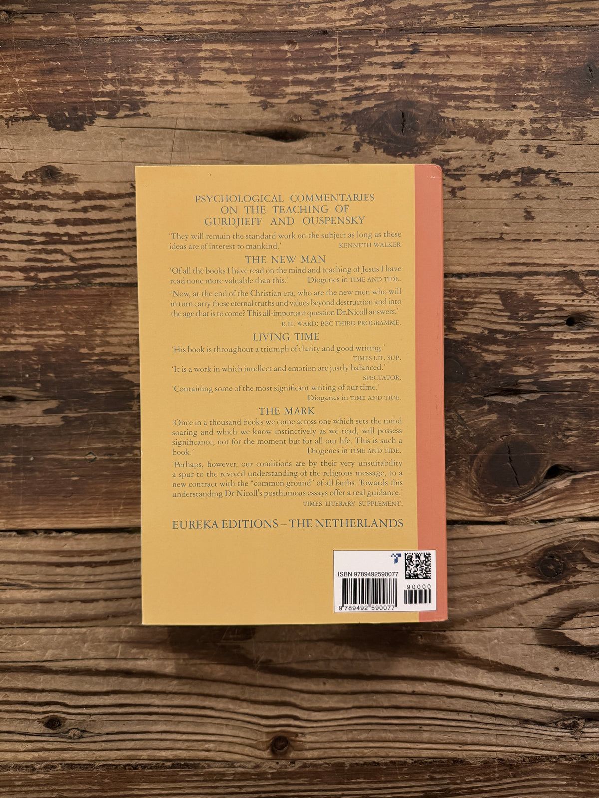 Back cover of a book titled 'Psychological commentaries on the teaching of Gurdjieff & Ouspensky, vol III' by Maurice Nicoll, lying on a wooden surface