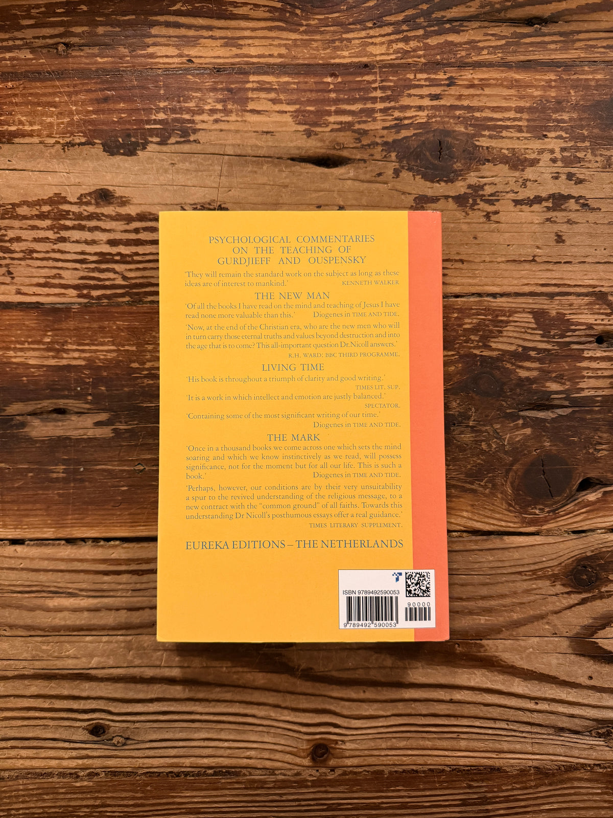 Back cover of a book titled 'Psychological commentaries on the teaching of Gurdjieff & Ouspensky, vol I' by Maurice Nicoll lying on wooden surface