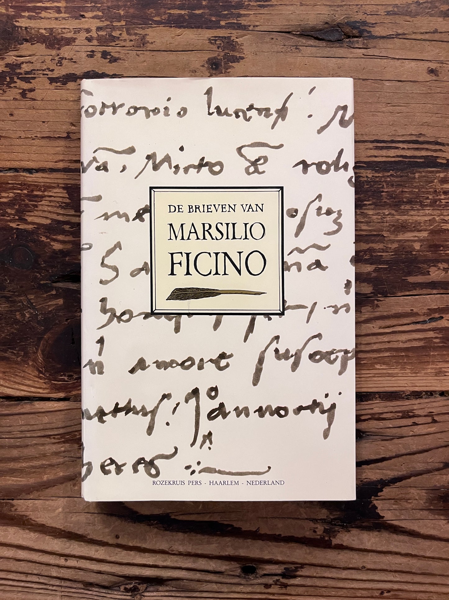foto van de omslag van het boek "de brieven van marsilio ficino" op houten achtergrond