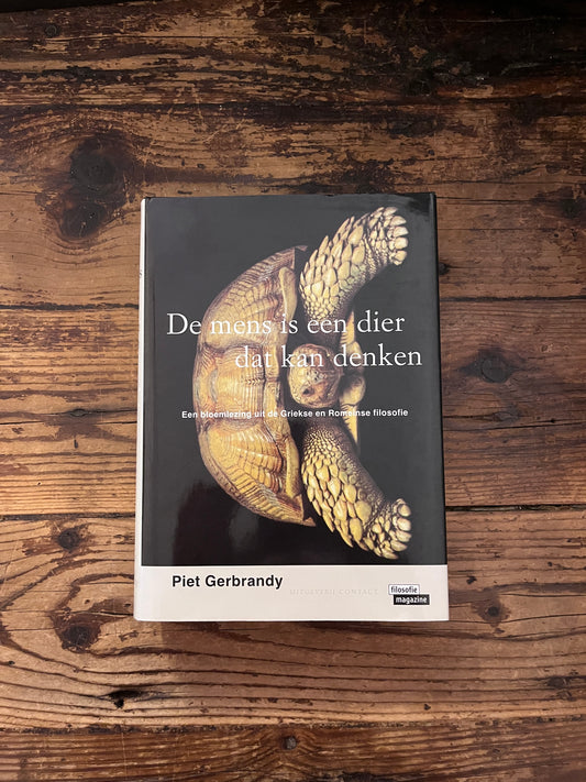 foto van de omslag van het boek " de mens is een dier dat kan denken" houten achtergrond