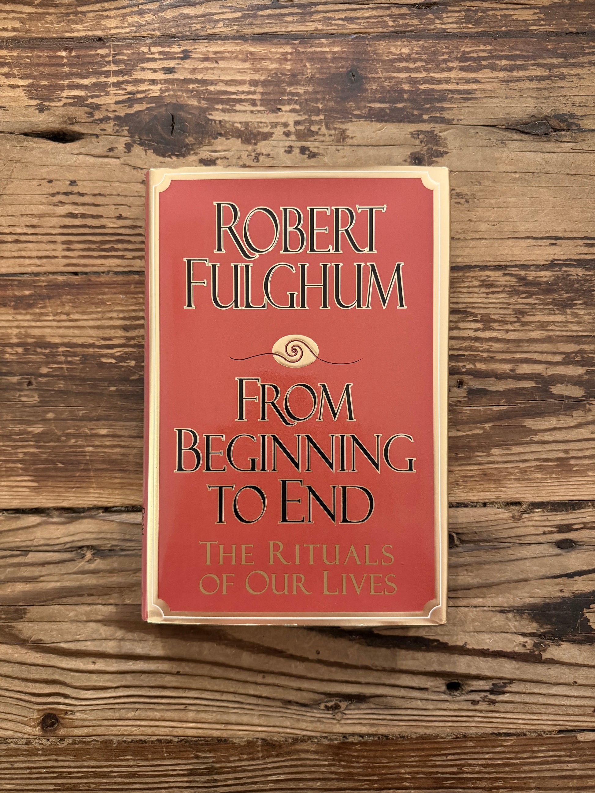 Front cover of a hardcover book titled 'From Beginning to End: The Rituals of Our Lives' by Robert Fulghum on a wooden surface