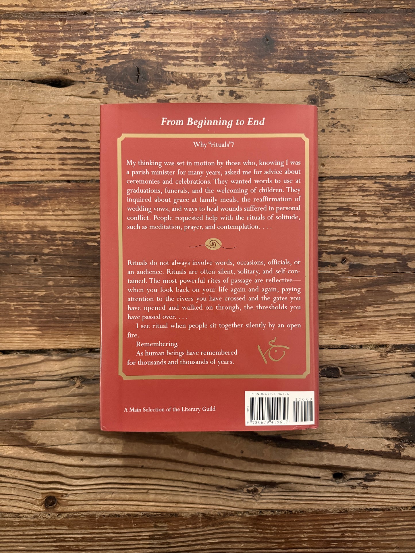 Back cover of a hardcover book titled 'From Beginning to End: The Rituals of Our Lives' by Robert Fulghum on a wooden surface
