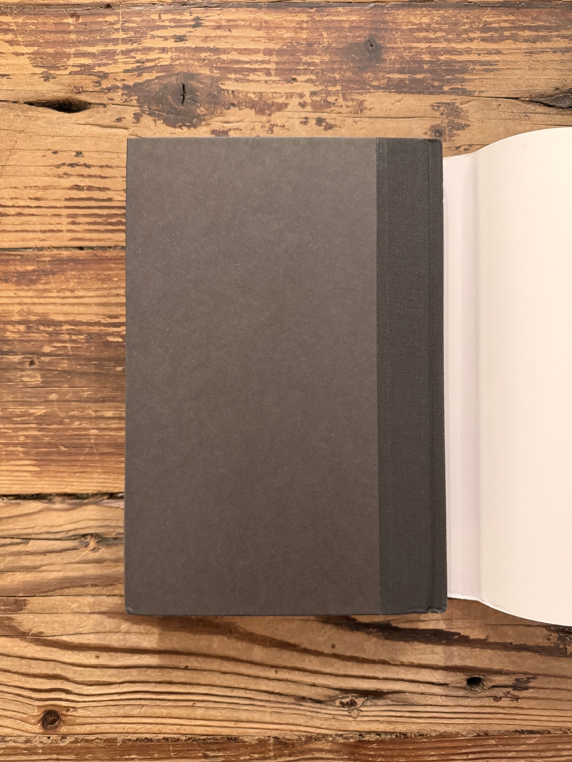 Back cover of a hardcover book titled 'From Beginning to End: The Rituals of Our Lives' by Robert Fulghum on a wooden surface