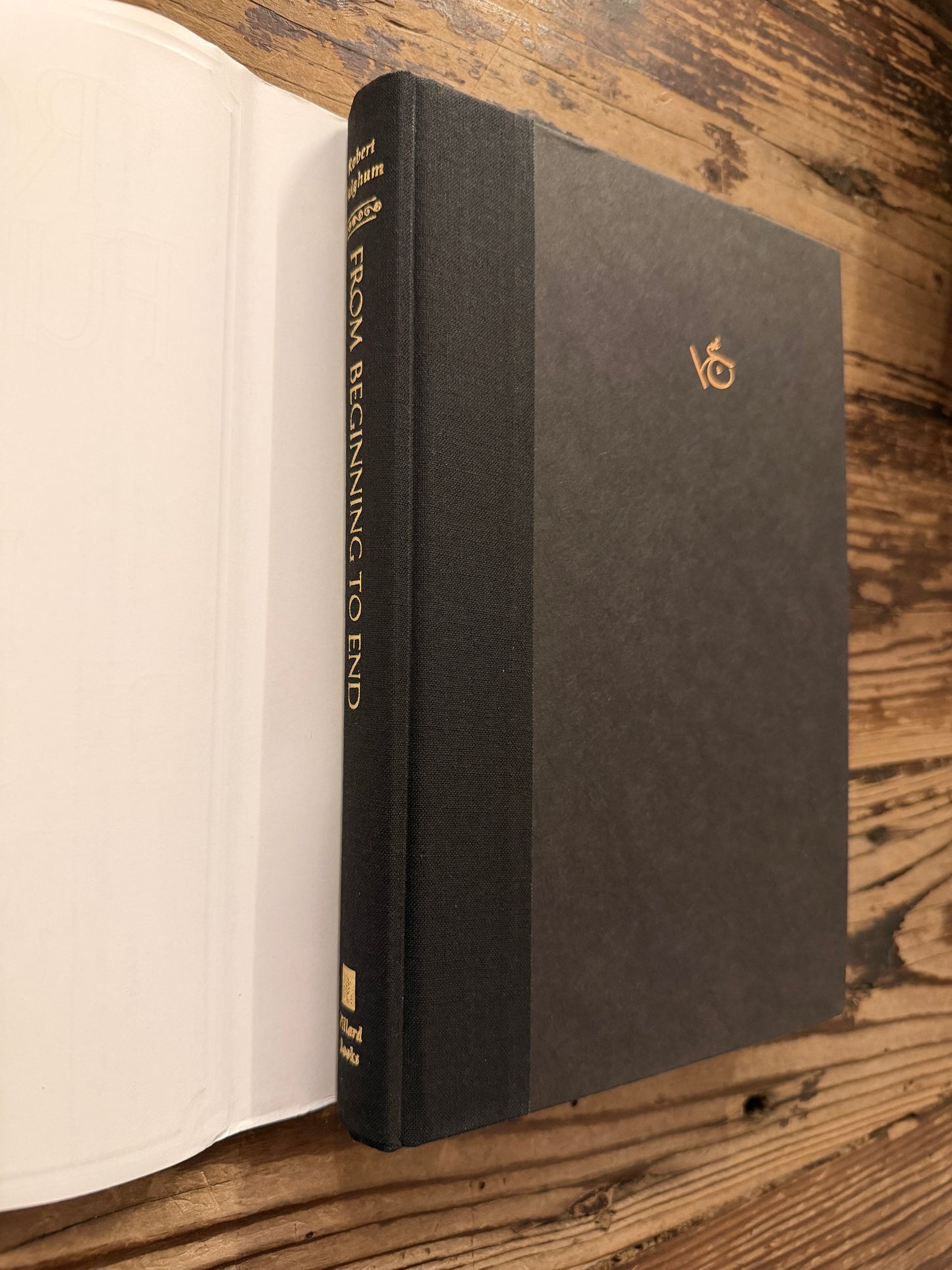 Front cover with out dust jacket of a hardcover book titled 'From Beginning to End: The Rituals of Our Lives' by Robert Fulghum on a wooden surface