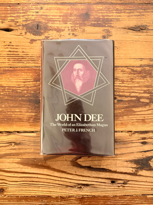 Front cover of a book titled 'John Dee: The World of an Elizabethan Magus' by Peter J. French on a wooden surface