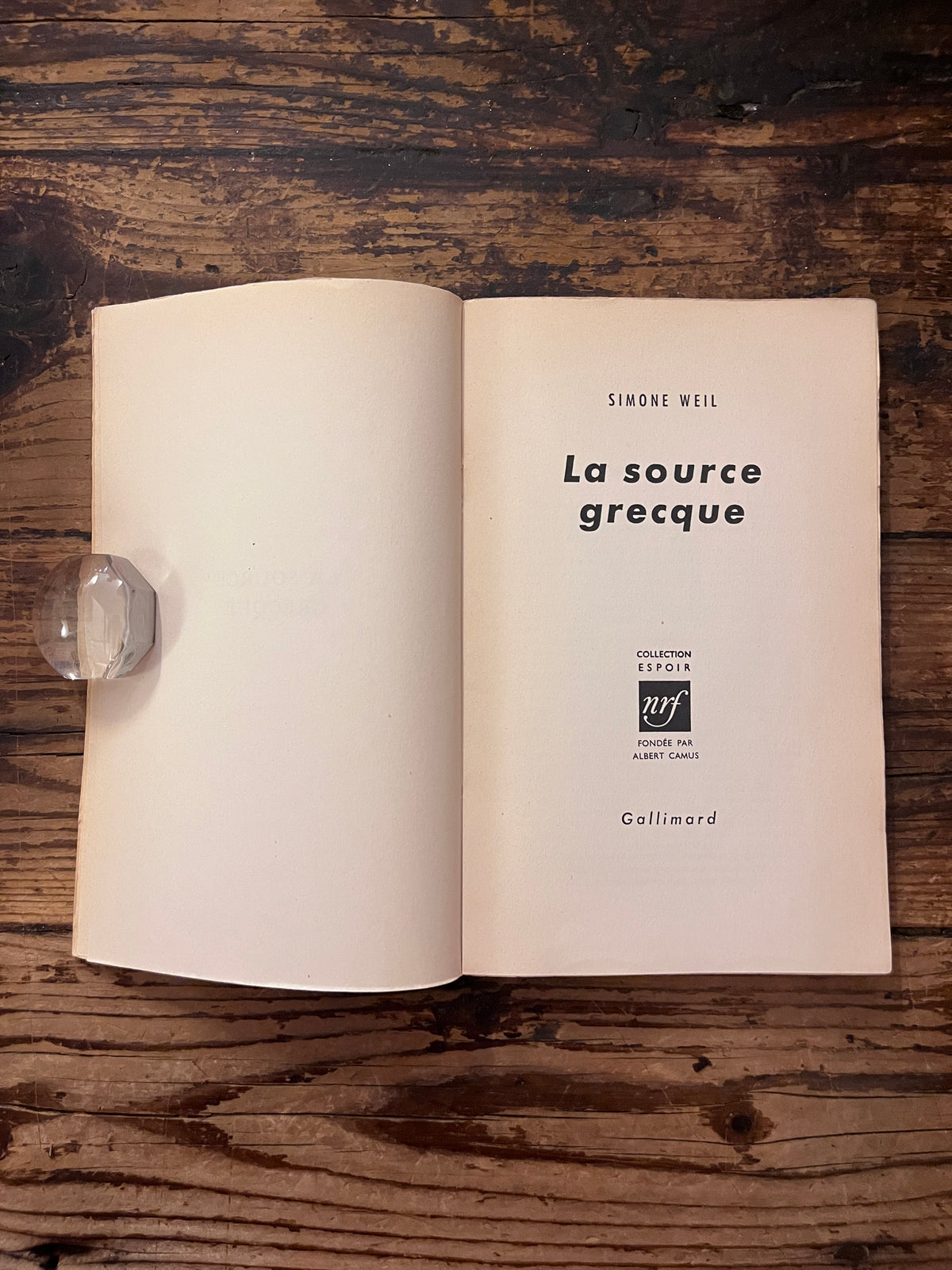 Photo de la page de titre du livre "la source Grecque" sur fond de bois