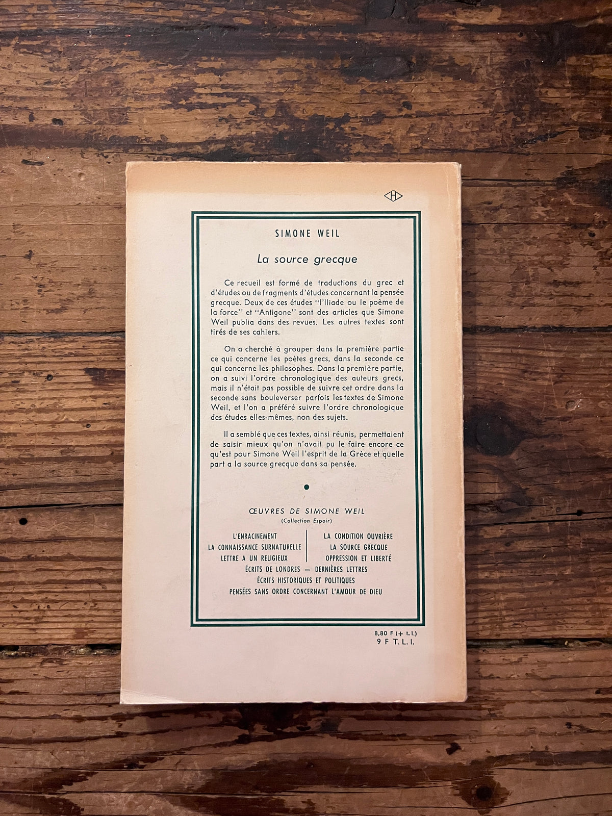Photo de la quatrieme de couverture du livre "la source Grecque" sur fond de bois