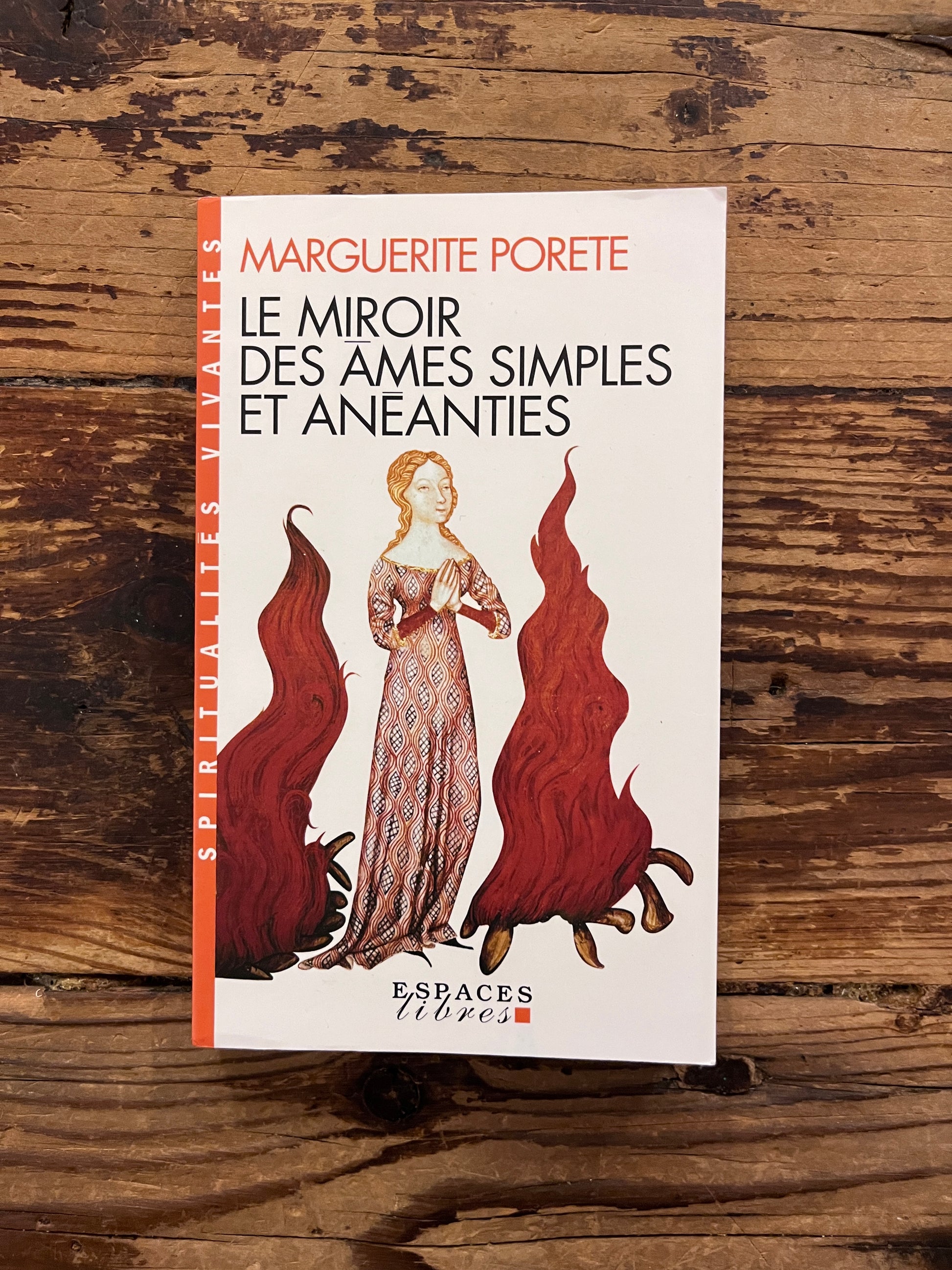 photo de la couverture du livre "le miroir des ames simples et aneanties" sur fond de bois