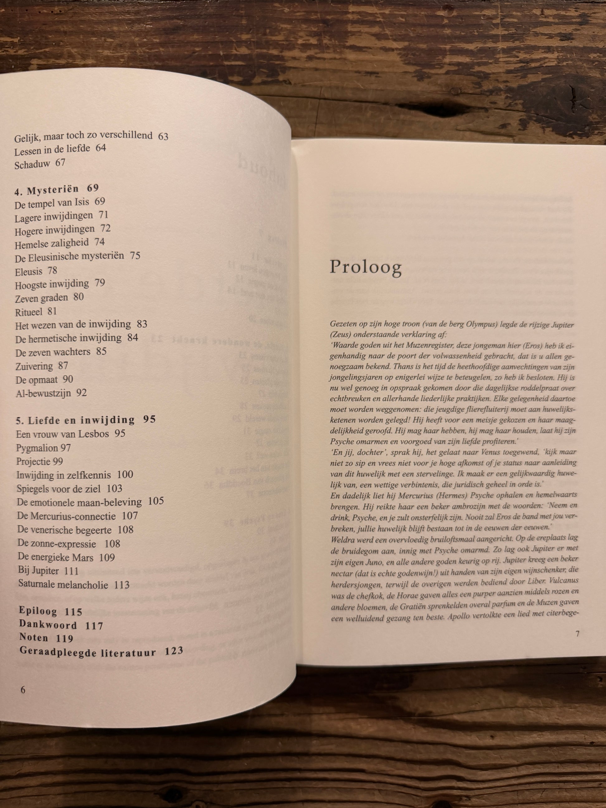 Open boek met de titel 'liefde & inwijding, van mythe naar beleving' door Jacob Slavenburg op een houten achtergrond 