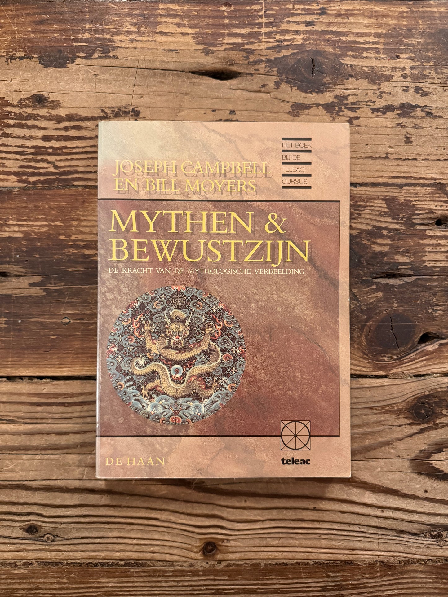 Voorkant van boek met de titel 'mythen & bewustzijn' door Joseph Campbell en Bill Moyers op een houten achtergrond 